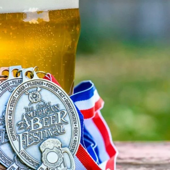 Médailles du GABF photographiées auprès de verres de bière