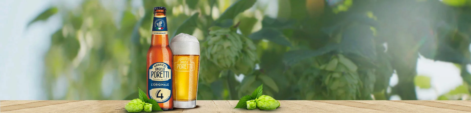 Bouteille et verre de Poretti 4 Luppoli avec des cônes de houblon